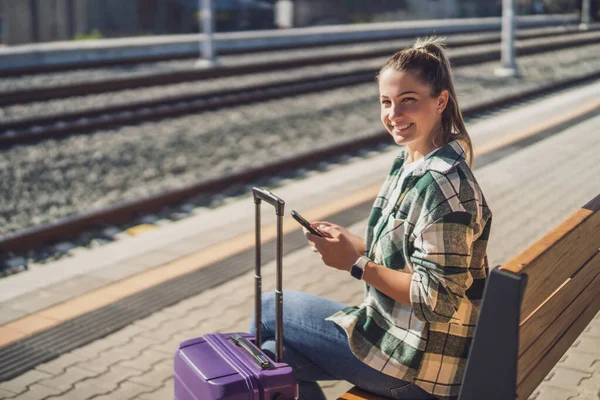Femme Heureuse Utilisant Téléphone Portable Assis Sur Banc Gare — Photo