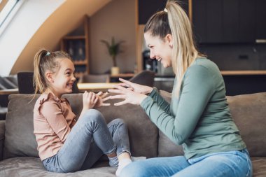 Happy mother and daughter enjoy spending time together at their home.