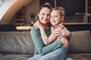 Happy mother and daughter enjoy spending time together at their home.