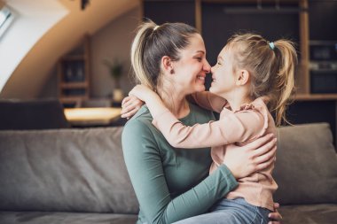 Happy mother and daughter enjoy spending time together at their home.