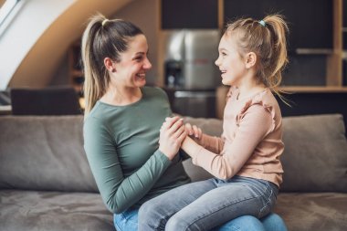 Happy mother and daughter enjoy spending time together at their home.