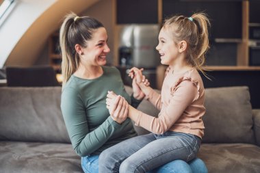 Happy mother and daughter enjoy spending time together at their home.