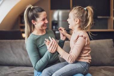 Happy mother and daughter enjoy spending time together at their home.