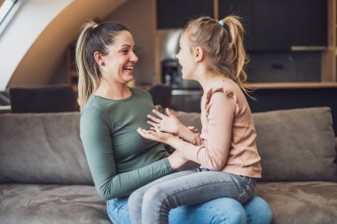 Happy mother and daughter enjoy spending time together at their home.
