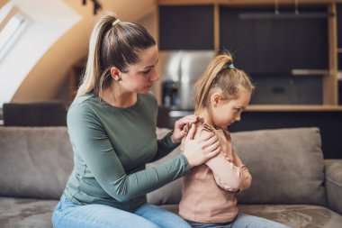 Mother is trying to comfort  her daughter after their conflict.