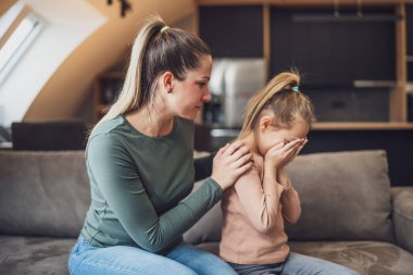 Mother is trying to comfort  her daughter after their conflict.