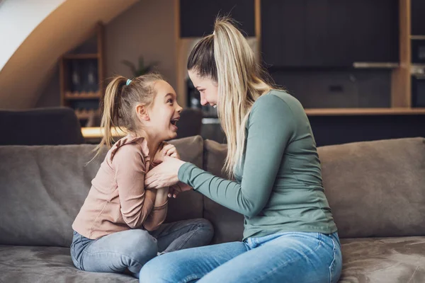 Happy mother and daughter enjoy spending time together at their home.