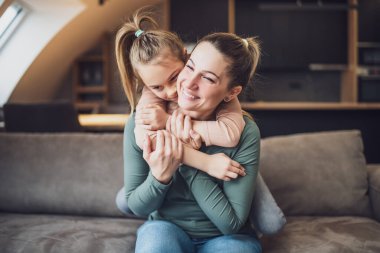 Happy mother and daughter enjoy spending time together at their home.