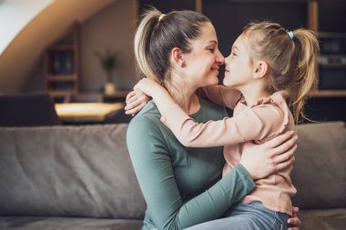 Happy mother and daughter enjoy spending time together at their home.