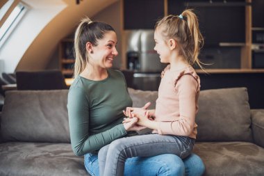Happy mother and daughter enjoy spending time together at their home.