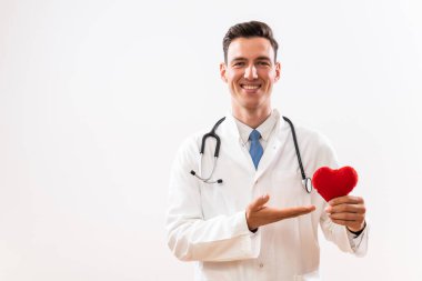 Kalp şeklini gösteren genç bir doktor resmi.