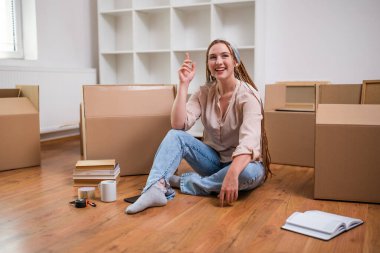 Örgülü modern kızıl kadın yeni evinde organizasyon hakkında fikir sahibi..