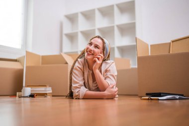 Örgülü modern kızıl kadın yeni daireye taşınıyor..