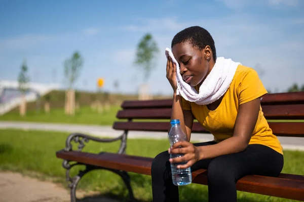 運動後の排出された女性はお湯を飲んでタオルで汗を拭き — ストック写真
