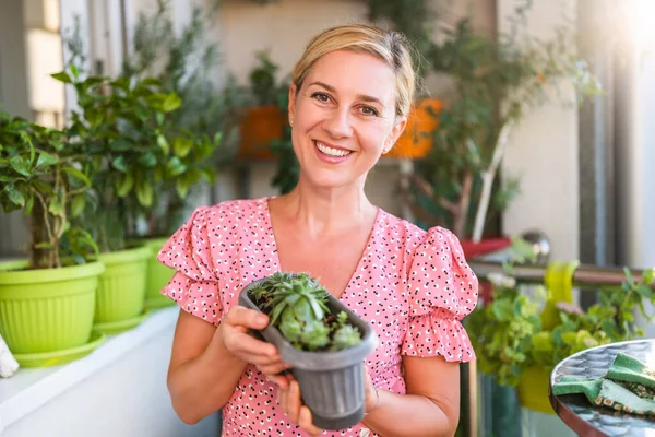 自宅のバルコニーでハッピーな女性ガーデニング 彼女は彼女のフーデック植物の成長を見ています — ストック写真