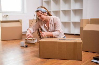 Örgülü modern kızıl kadın yeni evine taşınıyor..