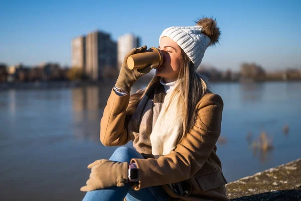 Piękna Kobieta Ciepłej Odzieży Pije Kawę Odpoczywa Nad Rzeką Słoneczny — Zdjęcie stockowe