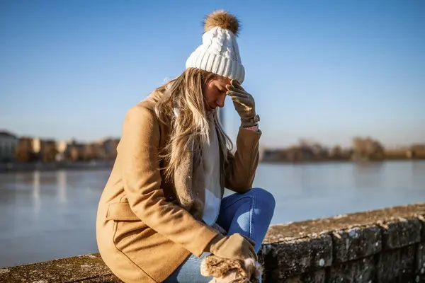 Worried Woman Warm Clothing Having Headache Sitting River Sunny Winter — Stock Photo, Image