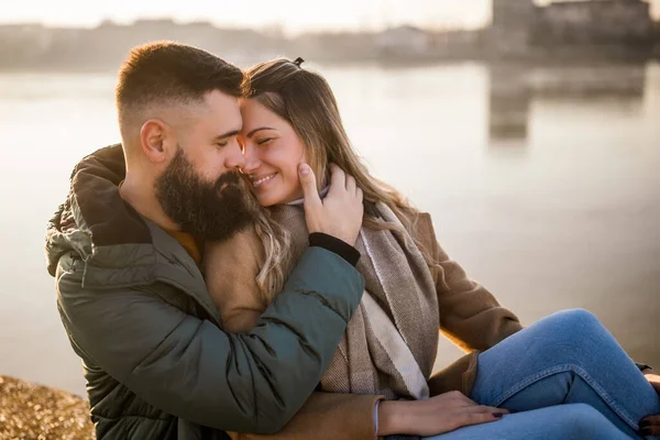 Lyckligt Par Omfamnar Medan Sitter Vid Floden — Stockfoto