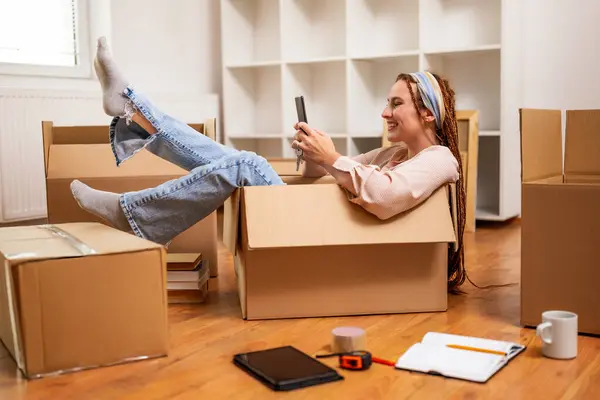 Szczęśliwa Kobieta Pomocą Telefonu Zabawy Podczas Przeprowadzki Nowego Mieszkania — Zdjęcie stockowe