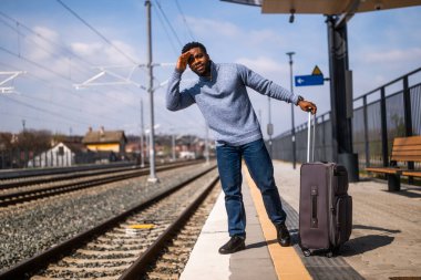 Tren istasyonunda dikilirken mutlu adam bakışlarını kaçırıyor..