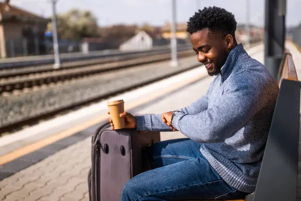 Счастливый Человек Чемоданом Кофе Смотрит Часы Сидя Скамейке Вокзале — стоковое фото