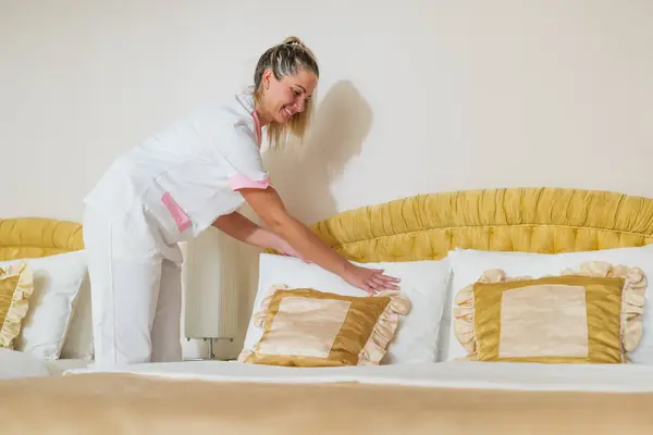 Hübsch Hotel Hausdienerin Herstellung Bett Ein Zimmer lizenzfreie Stockfotos
