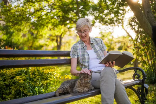 Счастливая Пожилая Женщина Любит Читать Книгу Проводить Время Своим Котом Лицензионные Стоковые Фото