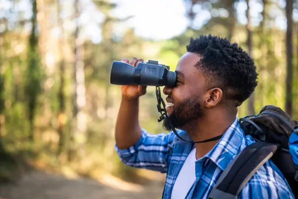 Young Man Enjoys Using Binoculars Hiking Nature Лицензионные Стоковые Изображения