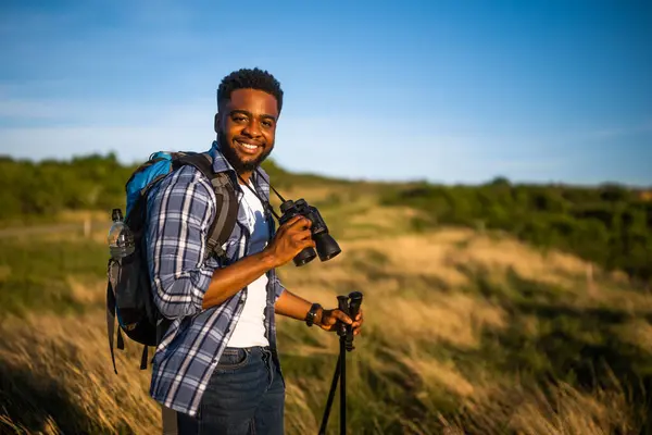 Young Man Enjoys Using Binoculars Hiking Nature Stockbild