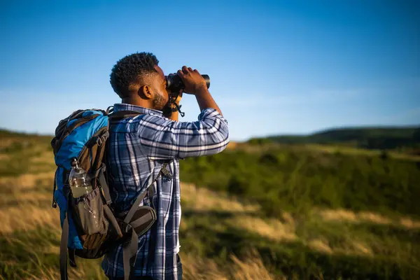 Young Man Enjoys Using Binoculars Hiking Nature Лицензионные Стоковые Изображения