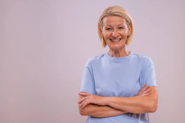 stock image Portrait of happy mature woman on a gray background.