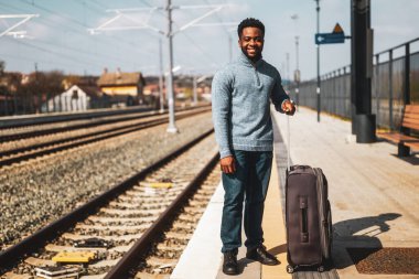  Tren istasyonunda duran bavullu mutlu adam..