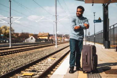  Tren istasyonunda duran bavullu mutlu adam..