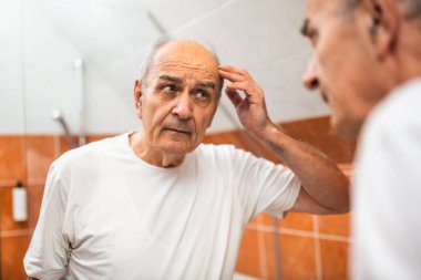 Son sınıf öğrencisinin portresi, saç dökülmesi ve banyo aynasında kendine baktığı için üzgün..