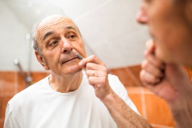 Son sınıf öğrencisinin portresi banyo aynasının önünde dikilirken burun kıllarını cımbızla çıkarıyor.. 
