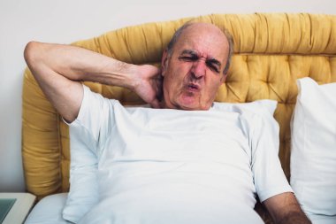 Son sınıf öğrencisi yatağında yatıyor, uyandıktan sonra boynunu acıdan tutuyor..