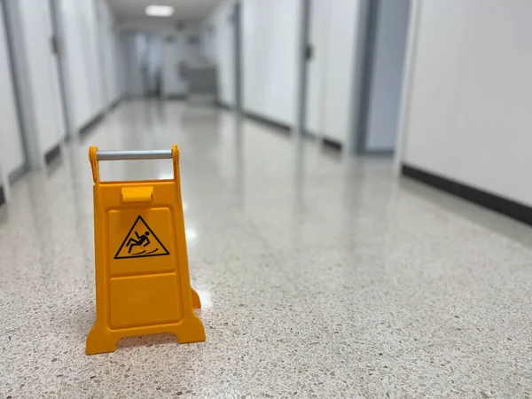 Slippery sign on wet floor in office building
