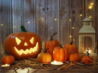 Cadılar Bayramı balkabağı başlıklı fener mumlu bir balkabağı ahşap arka planda