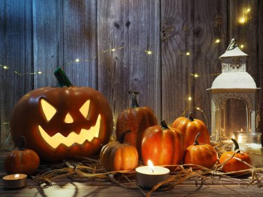 Cadılar Bayramı balkabağı başlıklı fener mumlu bir balkabağı ahşap arka planda