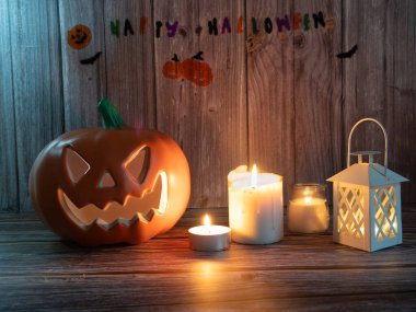 Cadılar Bayramı balkabağı başlıklı fener mumlu bir balkabağı ahşap arka planda