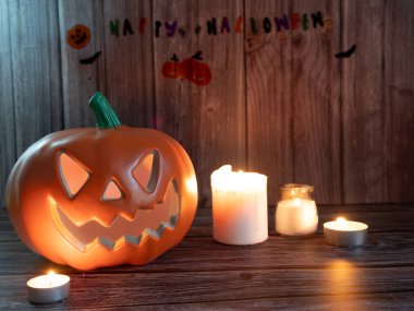 Cadılar Bayramı balkabağı başlıklı fener mumlu bir balkabağı ahşap arka planda