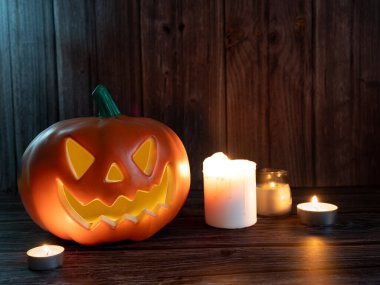 Cadılar Bayramı balkabağı başlıklı fener mumlu bir balkabağı ahşap arka planda