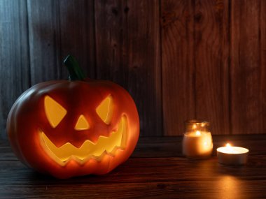 Cadılar Bayramı balkabağı başlıklı fener mumlu bir balkabağı ahşap arka planda