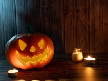 Cadılar Bayramı balkabağı başlıklı fener mumlu bir balkabağı ahşap arka planda