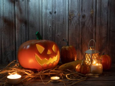 Cadılar Bayramı balkabağı başlıklı fener mumlu bir balkabağı ahşap arka planda