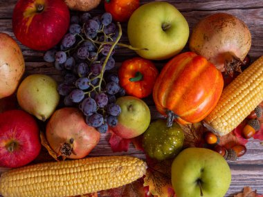 Sonbahar hala hayattır. Tahta masada farklı meyveler, sebzeler ve balkabağı.
