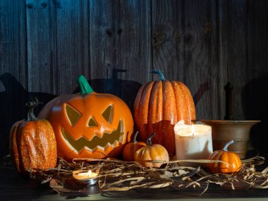 Cadılar Bayramı balkabağı başlıklı fener mumlu bir balkabağı ahşap arka planda