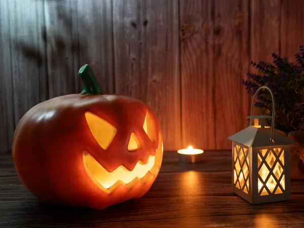 Cadılar Bayramı balkabağı başlıklı fener mumlu bir balkabağı ahşap arka planda