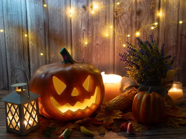 Halloween pumpkin head lantern with candles an pumpkin on wooden background